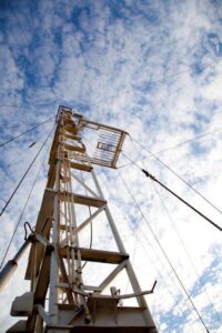 Low-angle view of a tall wooden tower against a cloudy sky.